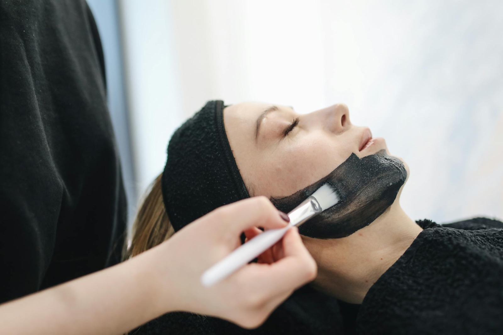 Soin du visage en cabine esthétique chez Beauty'Zen : application d'un masque sur une cliente détendue
